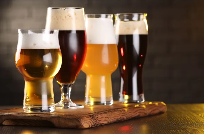 Variedad de estilos de cerveza artesanal en vasos: IPA, pilsner, porter, sour, wheat beer para principiantes