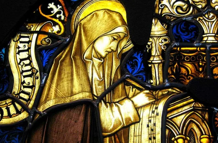 Santos cerveceros: los patrones que protegen la cerveza desde la Edad Media 10 Vitral de Santa Hildegarda de Bingen escribiendo, la abadesa benedictina que documento el uso del lupulo en la cerveza medieval en su obra Physica
