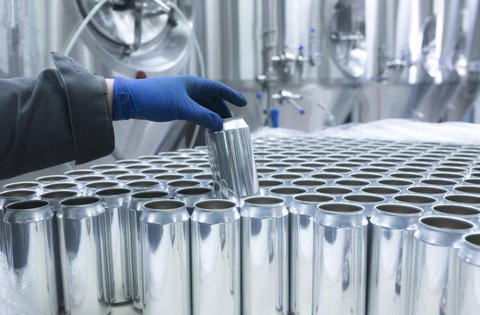 Latas de cerveza en una línea de envasado, encarecidas por los aranceles al aluminio en Canadá
