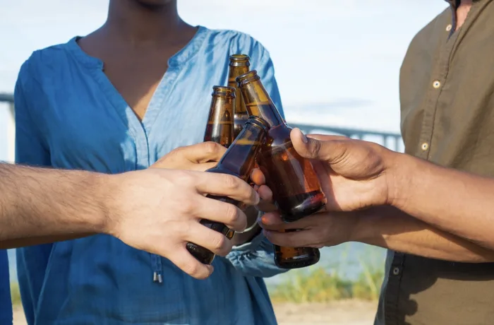 Amigos brindando con cervezas, industria cervecera colombiana y gestión del agua
