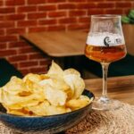Copa de cerveza junto a un cuenco de patatas fritas, el aperitivo más pedido en Castilla-La Mancha