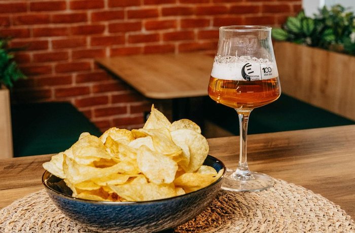 Copa de cerveza junto a un cuenco de patatas fritas, el aperitivo más pedido en Castilla-La Mancha