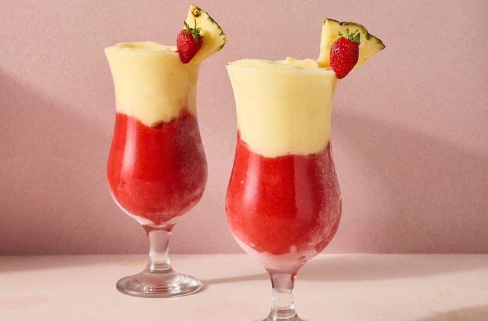 Cóctel Miami Vice de piña colada y daiquiri de fresa en capas