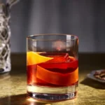 Negroni Week Chile, cóctel Negroni con piel de naranja sobre barra de bar