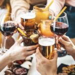 Jóvenes brindan con copas de vino, cerveza y bebidas mezcladas en México