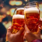 Brindis con vasos de cerveza rubia en un bar, mercado cervecero de Colombia