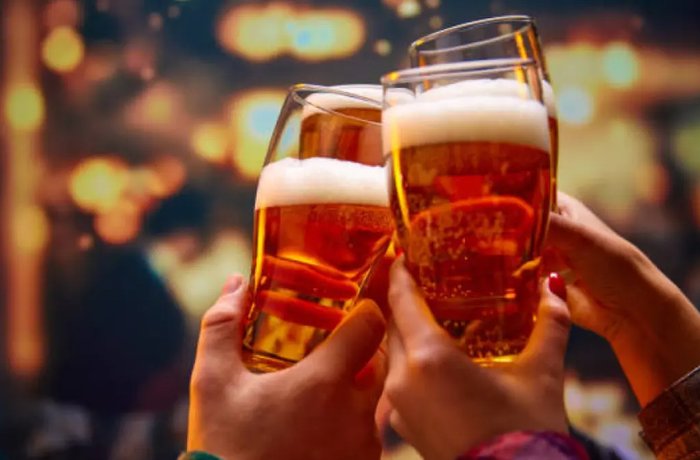 Brindis con vasos de cerveza rubia en un bar, mercado cervecero de Colombia