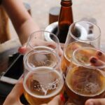 Amigos brindando con cerveza en una terraza, momento de consumo de cerveza sin alcohol en España