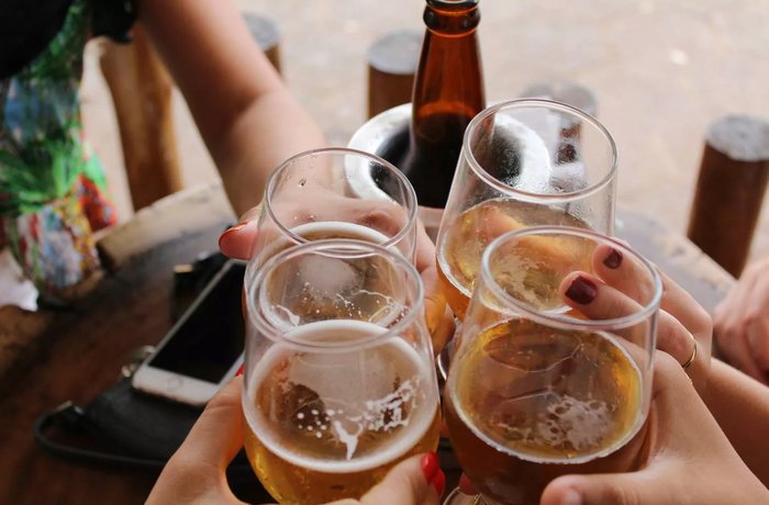 Amigos brindando con cerveza en una terraza, momento de consumo de cerveza sin alcohol en España