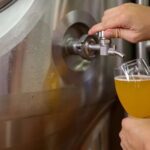 Cervecero revisando la calidad de la cerveza en una fábrica, como la de Velké Březno de donde Heineken saca la producción de Březňák