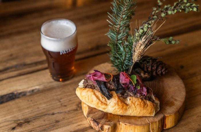 Sándwich de cordero braseado y pinta de Cerveza Patagonia, parte del menú de Bariloche a la Carta
